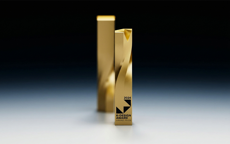 Trofeo K-Design Award dorado, con torsión helicoidal y el grabado en negro en la cara frontal de la base